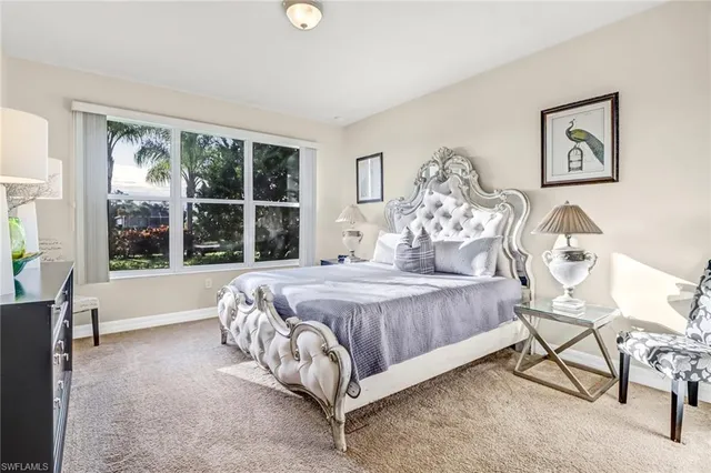 a bed sitting in a spacious bedroom next to a window