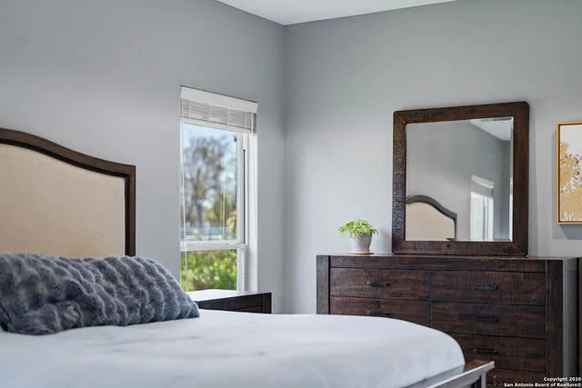 a bedroom with a bed and a dresser with mirror