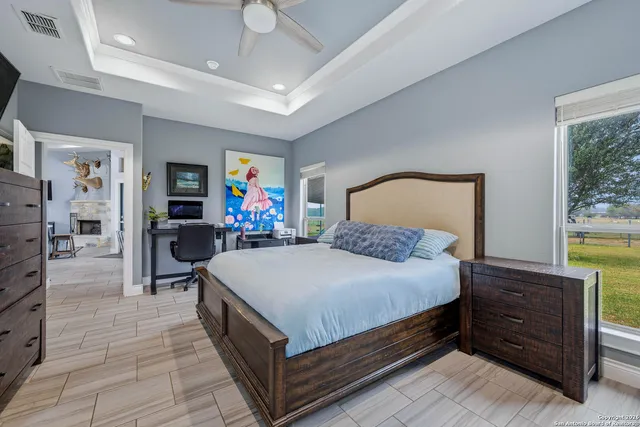 a large bedroom with a bed and a flat tv screen on dresser