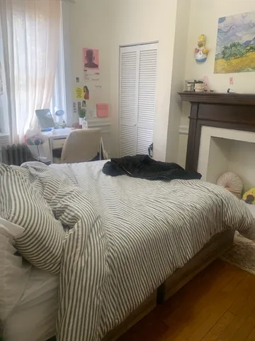 a bedroom with a bed and painting on the wall