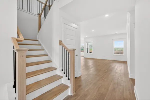 a view of kitchen with kitchen island wooden floor appliances and cabinets