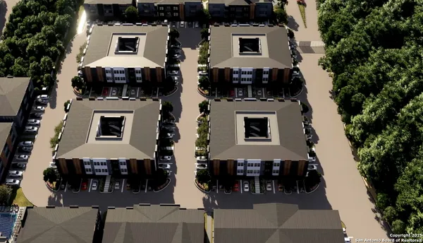 an aerial view of a house with a yard and large tree