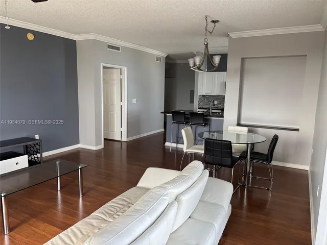a living room with furniture a flat screen tv and kitchen view