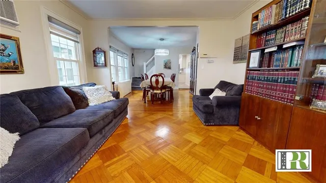 a living room with furniture a bookshelf and a window