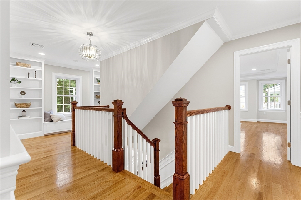 345 Grove Street Reading, MA 01867 - Photo 21 of 42 a view of a hallway with wooden floor and staircase