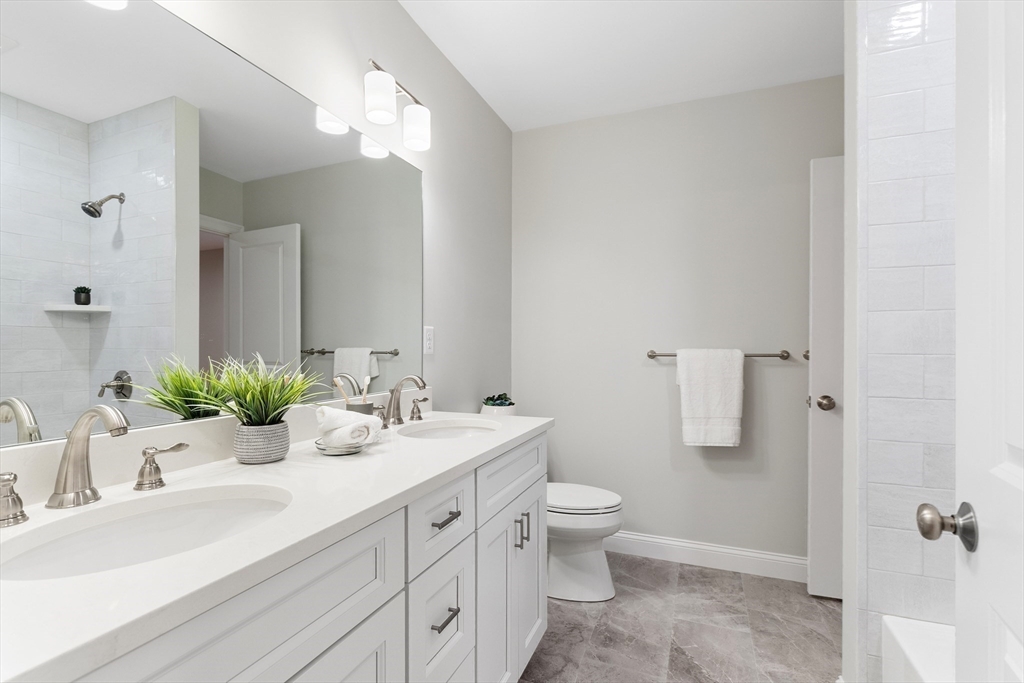 345 Grove Street Reading, MA 01867 - Photo 32 of 42 a bathroom with a sink double vanity and a mirror