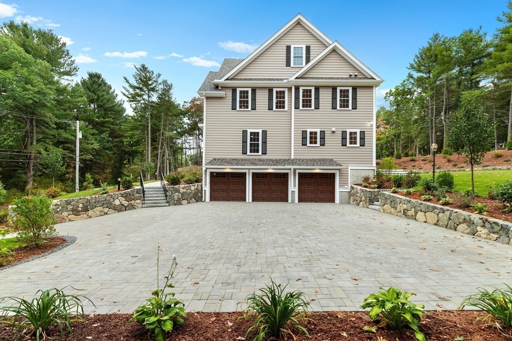345 Grove Street Reading, MA 01867 - Photo 5 of 42 a front view of a house with a yard and garage
