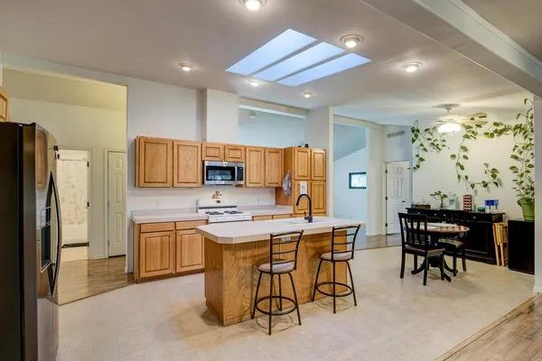 a kitchen with stainless steel appliances granite countertop a stove a sink and a microwave