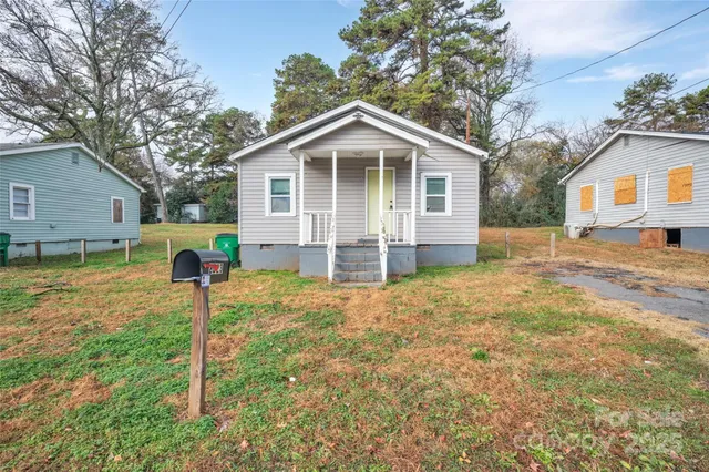 a view of a house with backyard and a tree