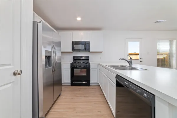 a kitchen with stainless steel appliances granite countertop a refrigerator and a sink