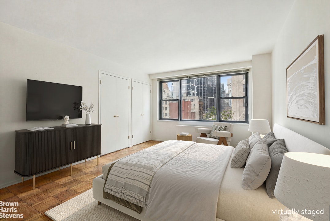 305 East 40th Street, Unit 4J Manhattan, NY 10016 - Photo 6 of 17 a bedroom with a bed and a flat screen tv