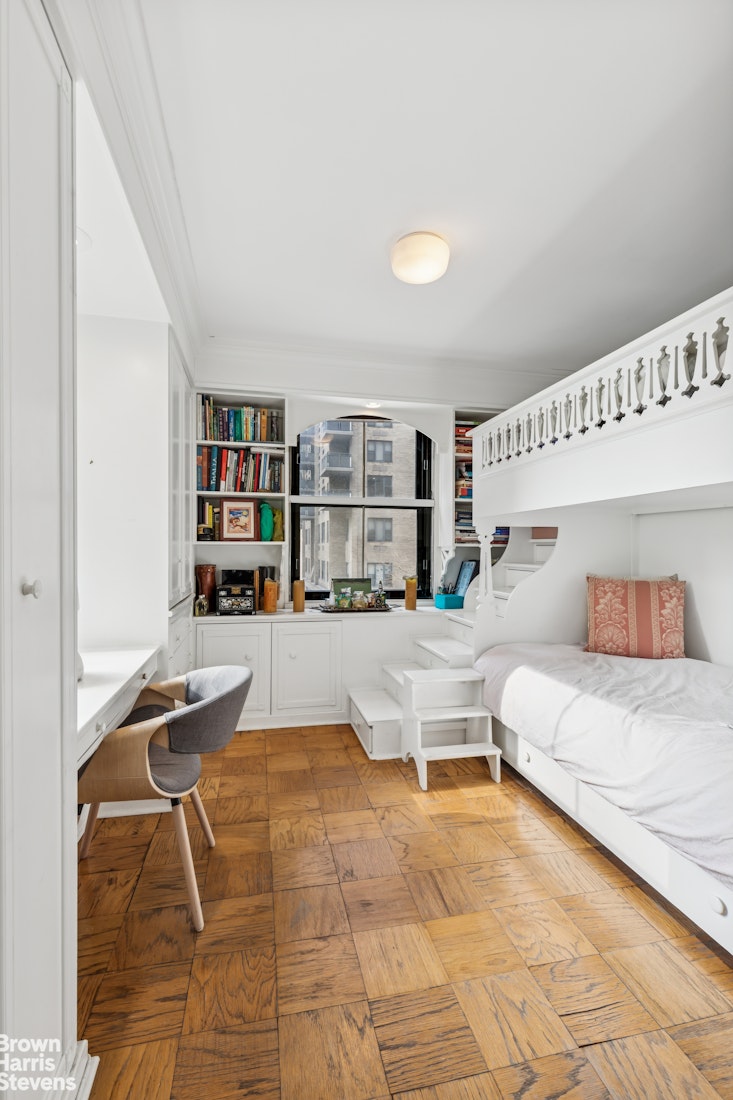 305 East 40th Street, Unit 4J Manhattan, NY 10016 - Photo 8 of 17 a living room with furniture and a book shelf