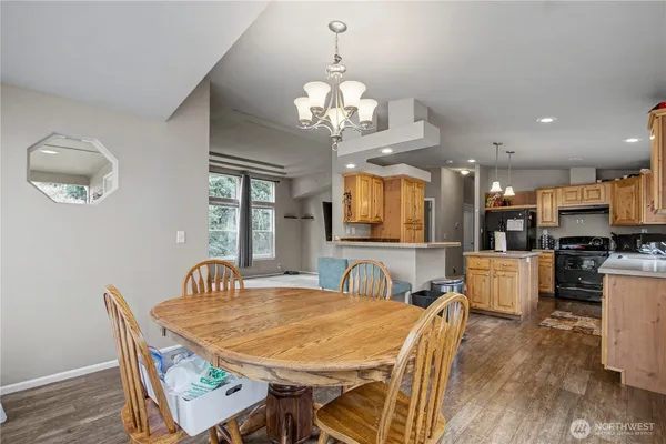 a view of a dining room with furniture a chandelier and wooden floor