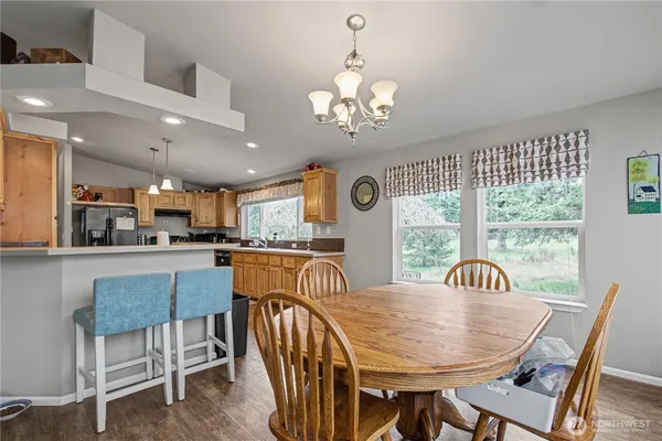a view of a dining room with furniture a chandelier and wooden floor