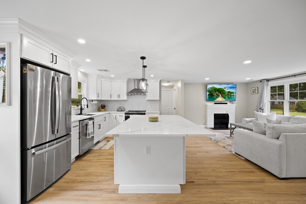 24 Francis Road Sharon, MA 02067 - Photo 16 of 41 a large open kitchen with stainless steel appliances kitchen island a stove a refrigerator a table and chairs