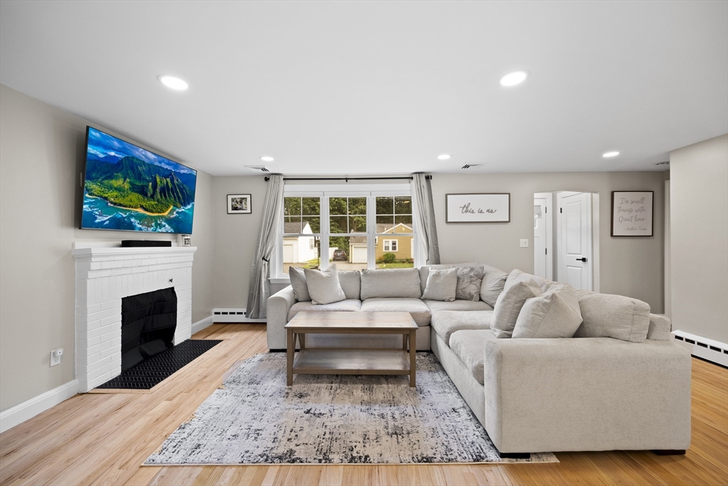 24 Francis Road Sharon, MA 02067 - Photo 9 of 41 a living room with furniture a flat screen tv and a fireplace