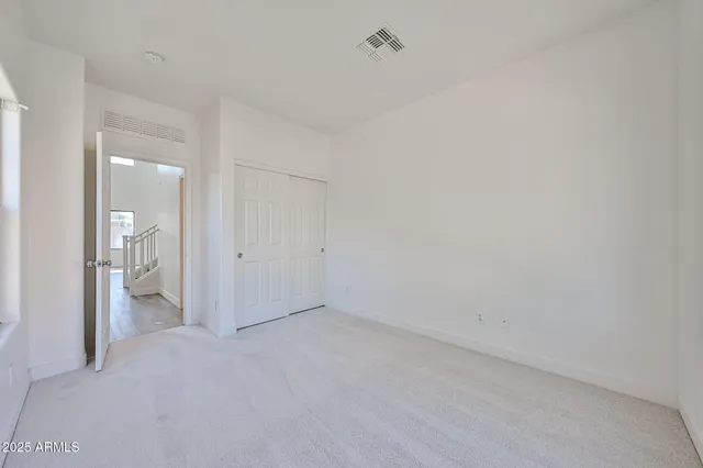 an empty room with wooden floor cabinet and windows