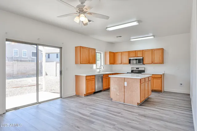a kitchen with stainless steel appliances granite countertop a sink stove cabinets and wooden floor