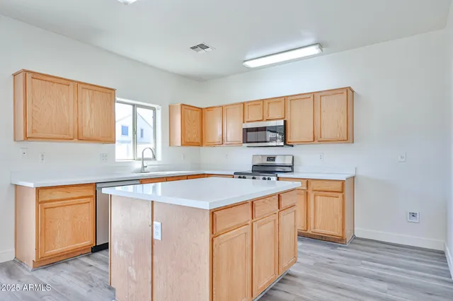 a kitchen with stainless steel appliances granite countertop a sink stove and wooden floor