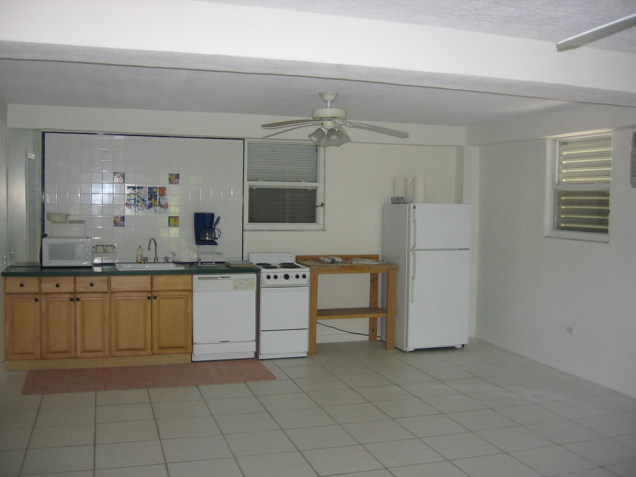 60 Southeast Marlin Avenue Key Largo, FL 33037 - Photo 33 of 46 a kitchen with a refrigerator and white cabinets