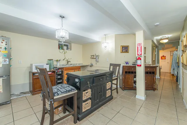 a kitchen with stainless steel appliances kitchen island granite countertop a table chairs and a refrigerator