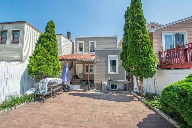 a front view of a house with plants and trees