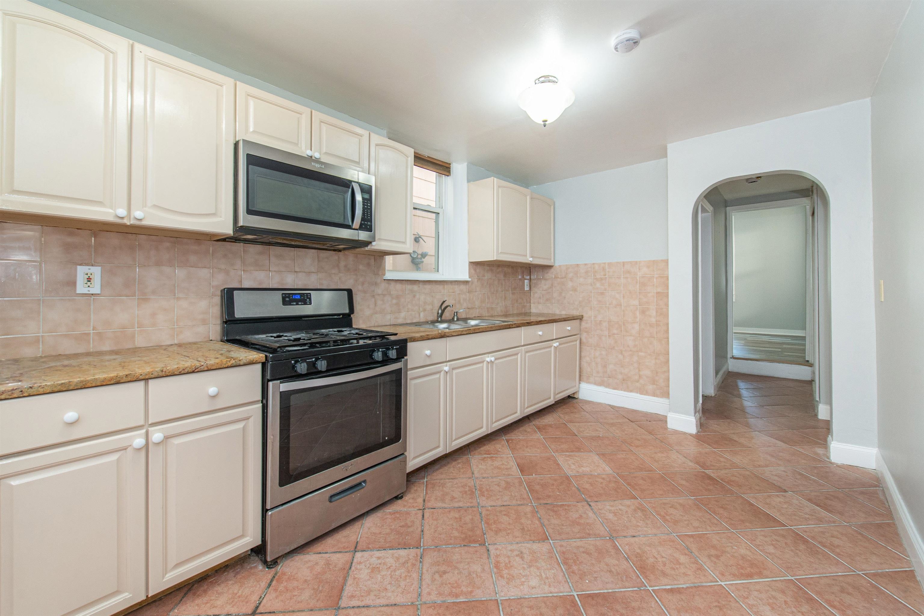 413 24th Street Union City, NJ 07087 - Photo 2 of 19 a kitchen with stainless steel appliances granite countertop a sink and a stove