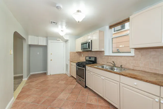 a kitchen with a sink stove top oven and refrigerator