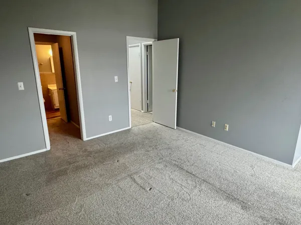 an empty room with closet and a bathroom