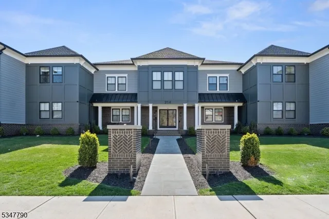 a front view of a house with garden and trees