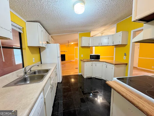 a kitchen with stainless steel appliances granite countertop a sink and a stove next to a window