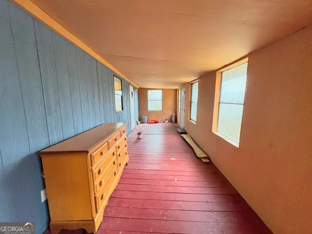 a hallway with wooden floor and furniture