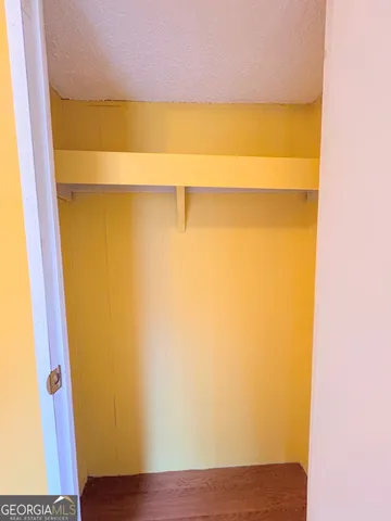 a view of closet with wooden floor