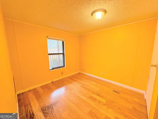 a view of a room with a wooden floor and a window