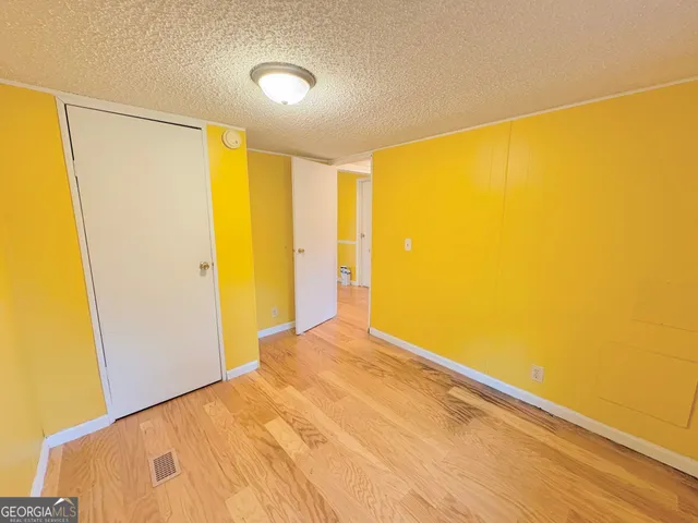 a view of a big room with wooden floor and windows