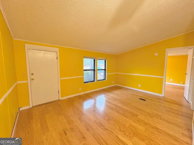 a view of an empty room with wooden floor