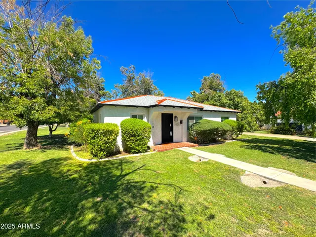 a view of a house with a big yard and potted plants