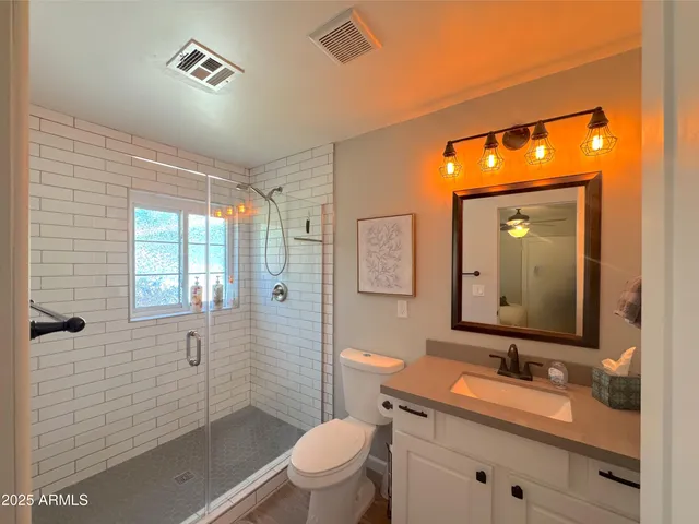 a bathroom with a toilet sink vanity and mirror