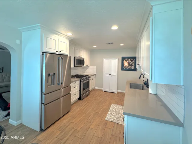 a kitchen with stainless steel appliances a refrigerator sink and stove