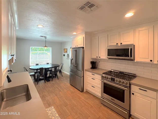 a kitchen with granite countertop a stove a sink and a microwave