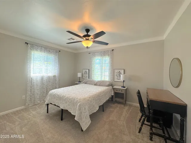 a bedroom with a bed a desk and chair with a bookshelf