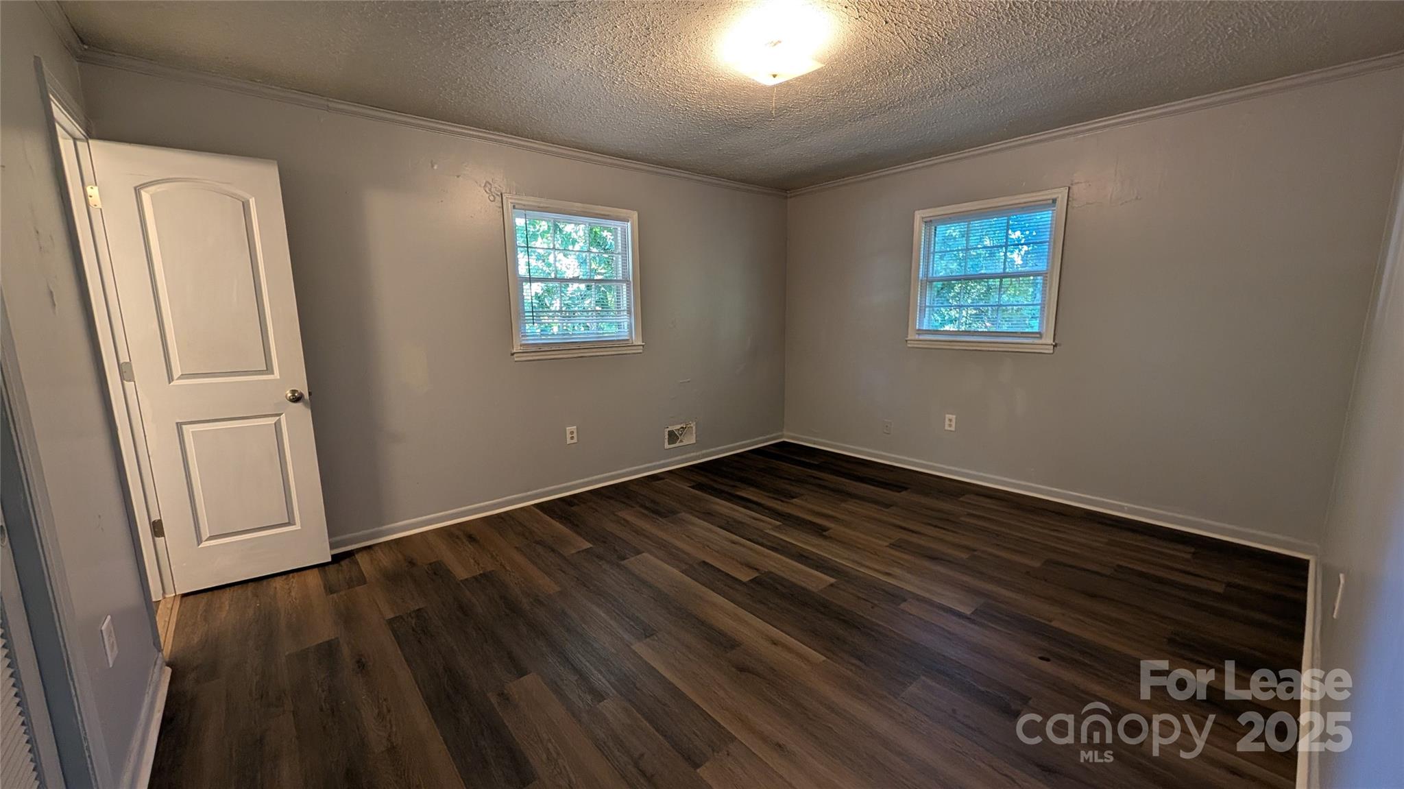 3889 Poplar Tent Road Concord, NC 28027 - Photo 21 of 33 an empty room with wooden floor and windows