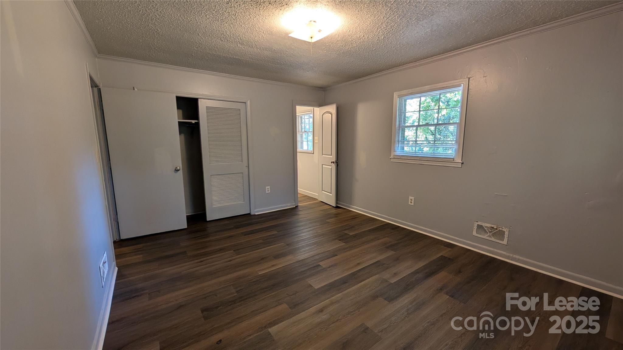 3889 Poplar Tent Road Concord, NC 28027 - Photo 22 of 33 an empty room with wooden floor and windows