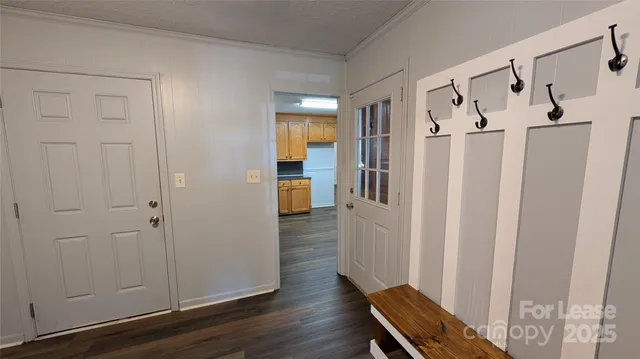 a view of a hallway with wooden floor and entryway