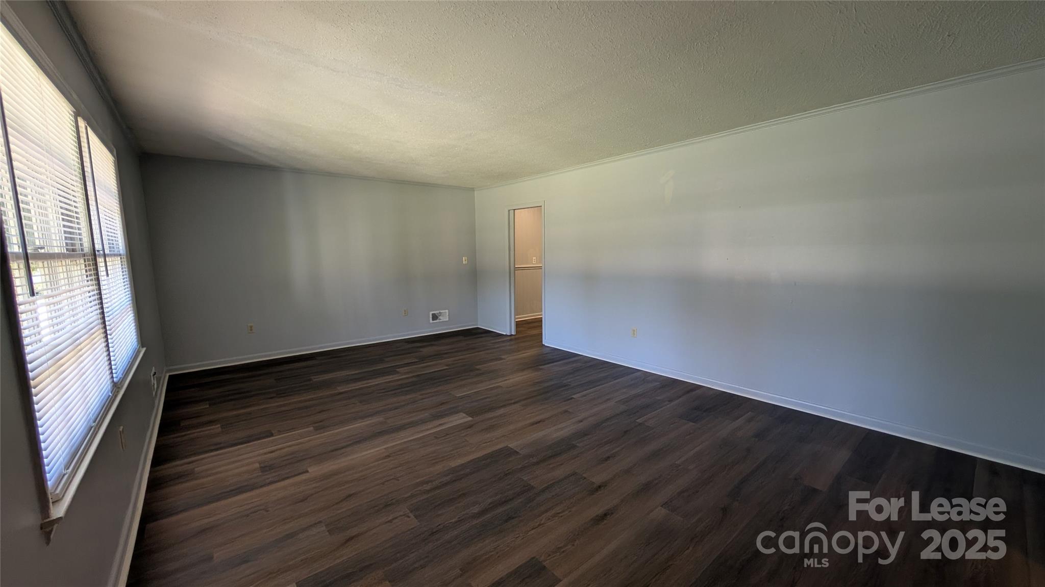 3889 Poplar Tent Road Concord, NC 28027 - Photo 6 of 33 an empty room with wooden floor and windows