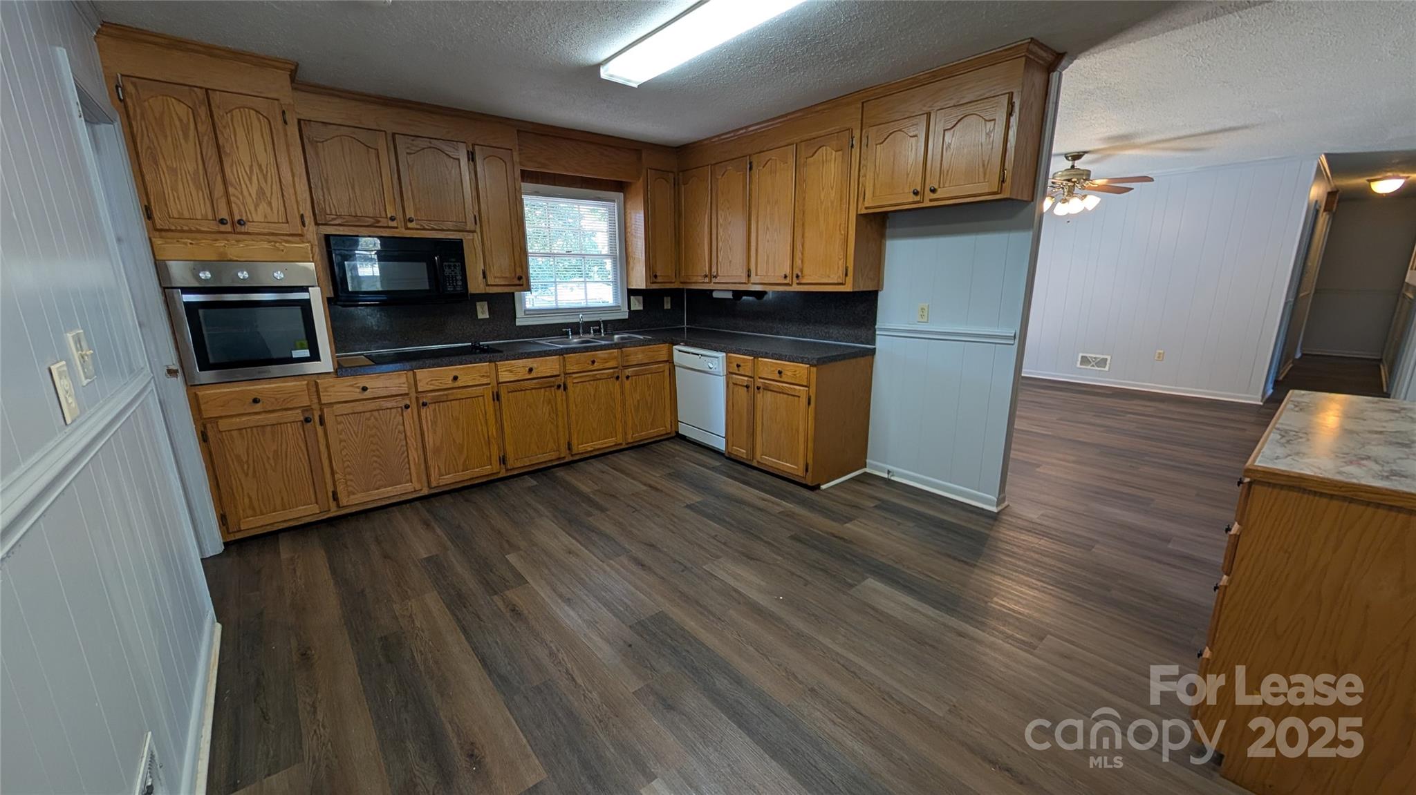 3889 Poplar Tent Road Concord, NC 28027 - Photo 8 of 33 a kitchen with granite countertop wooden floors a sink and a stove