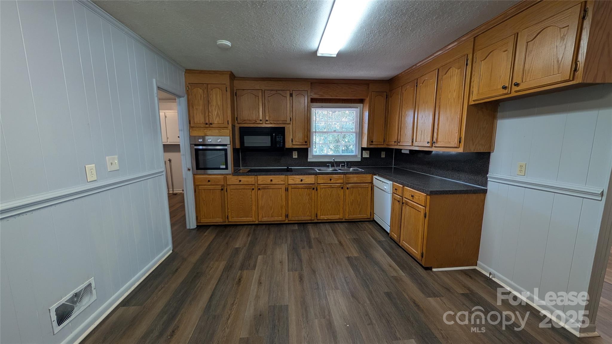 3889 Poplar Tent Road Concord, NC 28027 - Photo 9 of 33 a kitchen with kitchen island granite countertop wooden cabinets a sink a stove and a refrigerator
