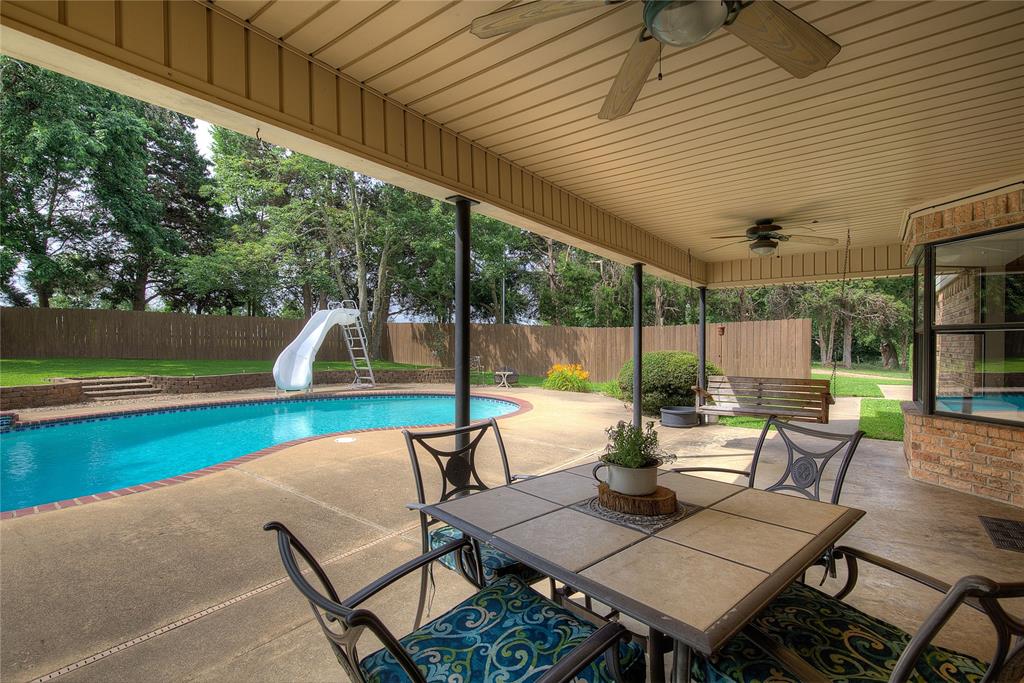 753 County Rd SW 3110 Mount Vernon, TX 75457 - Photo 30 of 40 The covered back porch has plenty of room for outdoor dining, plus concrete decking around a 32x16 gunite pool with slide and waterfall!