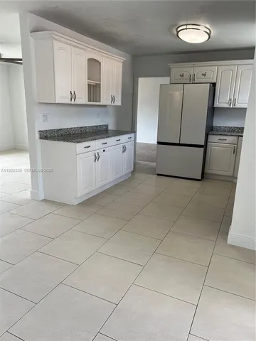 a kitchen with granite countertop white cabinets and stainless steel appliances