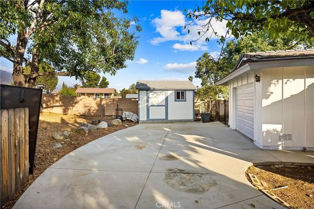 a kitchen with stainless steel appliances kitchen island granite countertop a dining table chairs sink and white cabinets